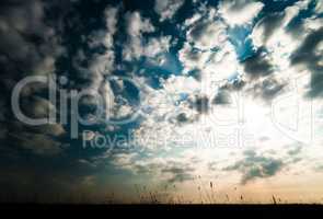 Horizontal ground silhouette with dramatic clouds and sunshine b