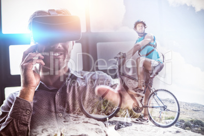 Composite image of fit man cycling on rocky terrain