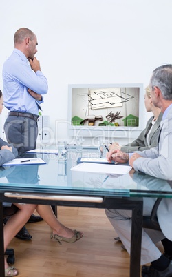 Composite image of business team looking at white screen