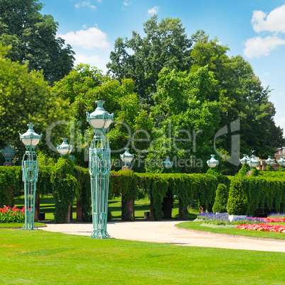 summer park with beautiful street lights, lawns and hedges