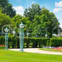 summer park with beautiful street lights, lawns and hedges
