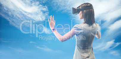 Composite image of rear view of businesswoman holding virtual gl