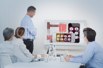 Composite image of business team looking screen