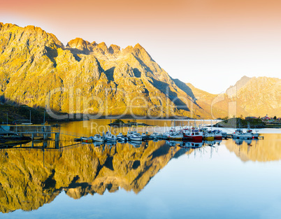 Horizontal vivid orange sunset in Norway fjords reflection lands