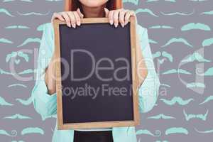 Composite image of smiling hipster woman holding blackboard