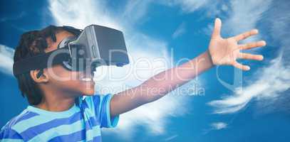Composite image of side view of little boy holding virtual glass
