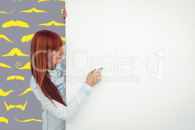 Composite image of smiling hipster woman behind a white card