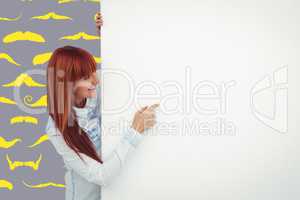 Composite image of smiling hipster woman behind a white card