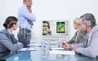 Composite image of business team looking at white screen