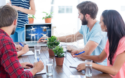 Composite image of business team using a laptop