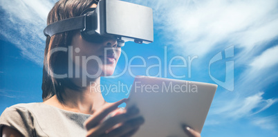Composite image of businesswoman holding virtual glasses and tab