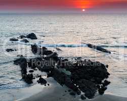 Horizontal vivid vibrant red orange Indian sunset ocean landscap