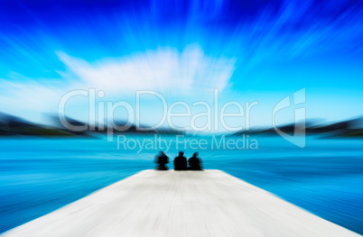 Horizontal vivid three freinds sitting on the quay motion blur a