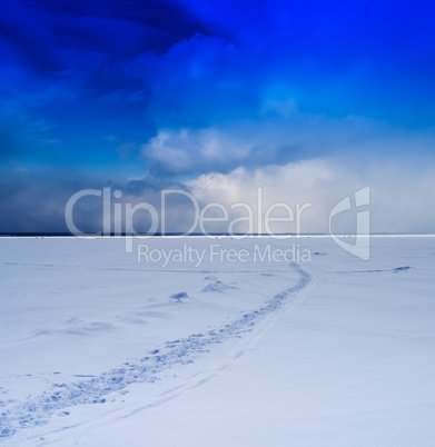 Square vivid winter morning on frozen lake footprints path cloud