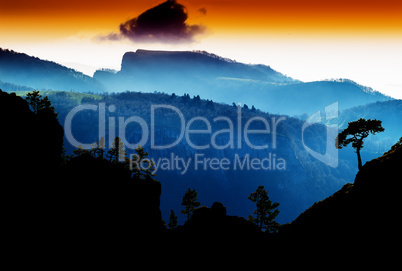 Horizontal vdramatic mountain trees on rocks silhouette sunset b