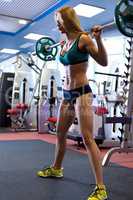 Sport. Slim woman exercising with barbell