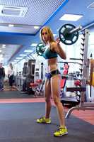 Beautiful girl posing with barbell during workout