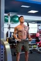 Handsome tattooed guy training with barbell