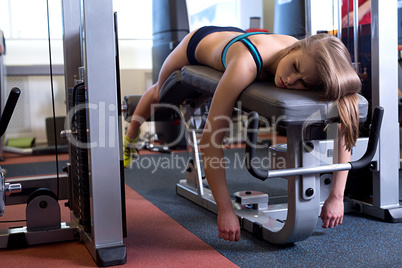Sport. Image of tired girl lying on bench at gym