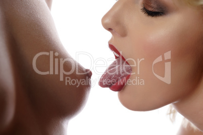 Woman stretches tongue to naked breast of mistress