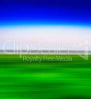 Square vivid green landscape with blue sky  motion blur abstract