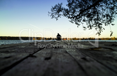 Lone fisherman sunset pier