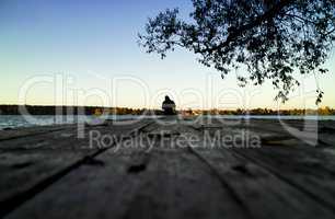 Lone fisherman sunset pier