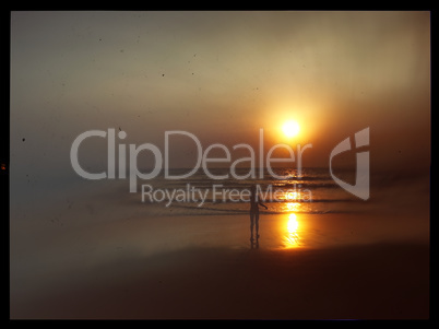 Horizontal vintage indian boy meeting sunset on the beach postca