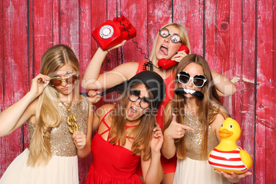 Photo Booth Party mit lustigen Probs - Junge Mädchen albern vor Fotobox herum