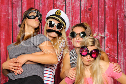 Junge Mädchen mit lustigen Brillen haben Spaß mit einer Fotobox
