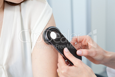 Doctor examining birthmarks and moles on a female patient