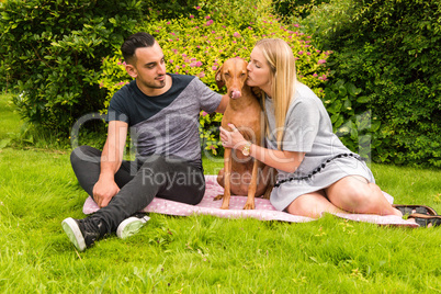 Couple on rug with woman kissing dog