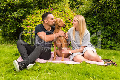 Couple on rug with man kissing dog