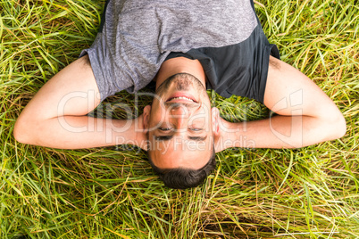 Close-up of man holding hands behind head