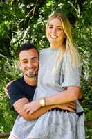 Smiling man holding blonde girlfriend on gate