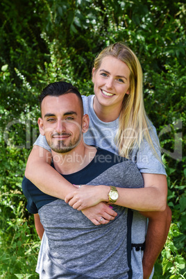 Smiling blonde woman with arms round boyfriend
