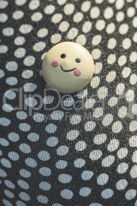 Smile icon on textile surface with points.