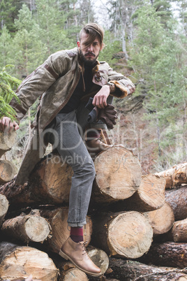 Young men on logs in the forest. Pine trees