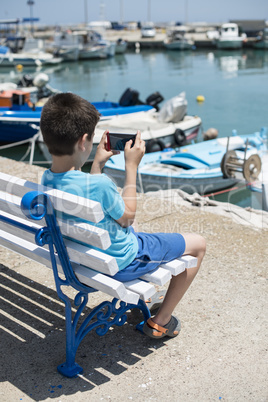 Child sitting on a bench on the beach