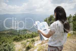 Woman with map high in the mountain