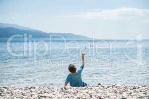 Children throw stones at the water of the sea