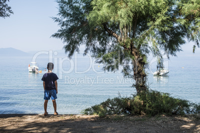 Child on the beach looking at the se