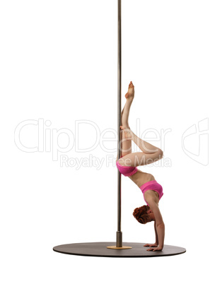 Pole dance. Red-haired woman doing handstand