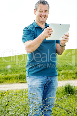 Man with tablet PC on the field