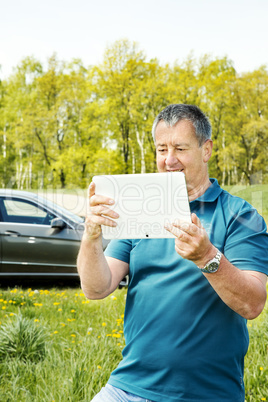 Man with Tablet PC and car