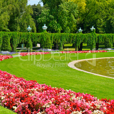 summer park with flower bed and green lawn