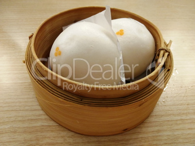 two siopao or chinese steamed bun in a bamboo steamer
