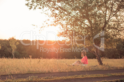 Girl with a book on nature reading under the tree