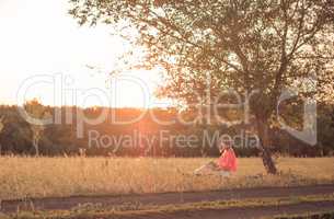 Girl with a book on nature reading under the tree