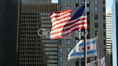 United States and Chicago Flags Waving on Chicago at Sunset